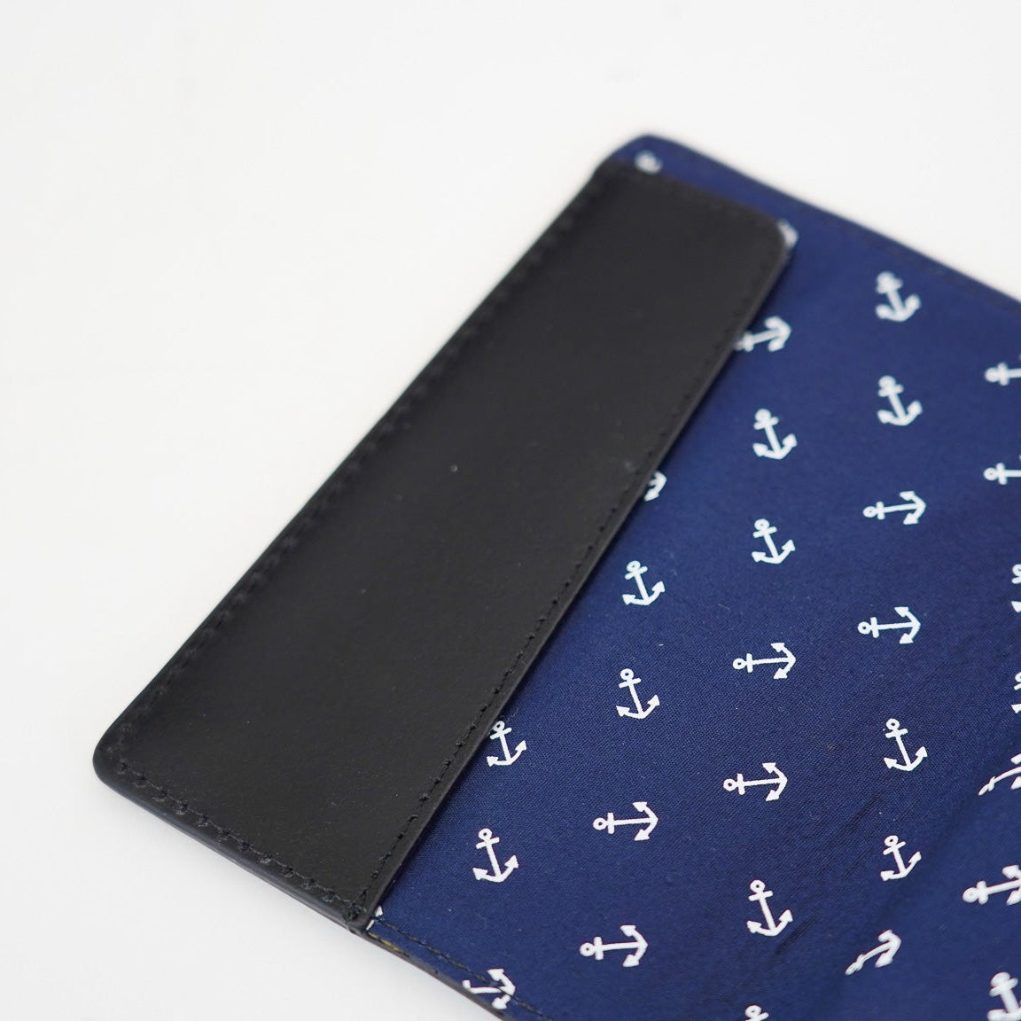 Blue passport holder with white anchor pattern on a white background