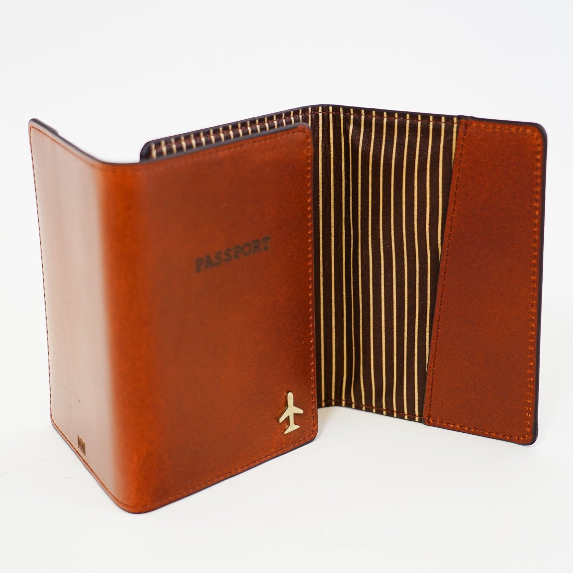 Brown leather passport holder with striped interior on a white background